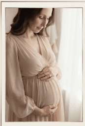 Expecting mother cradling her belly, soft monochrome portrait